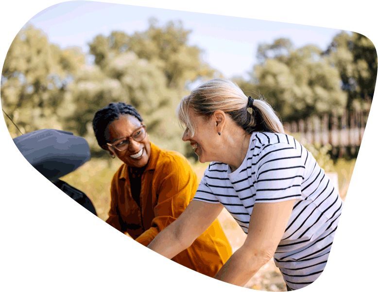 women putting items into trunk of car